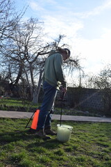 Young man engaged in household chores and small-scale rural farming, tending to his garden with...