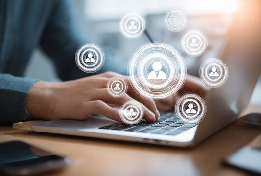 Person typing on a laptop with floating user profile icons, symbolizing online networking or social media interaction.