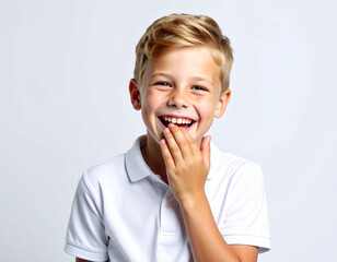 Cara y expresion de felicidad de un ni&ntilde;o de raza blanca riendo con la mano en la cara aislado en fondo blanco