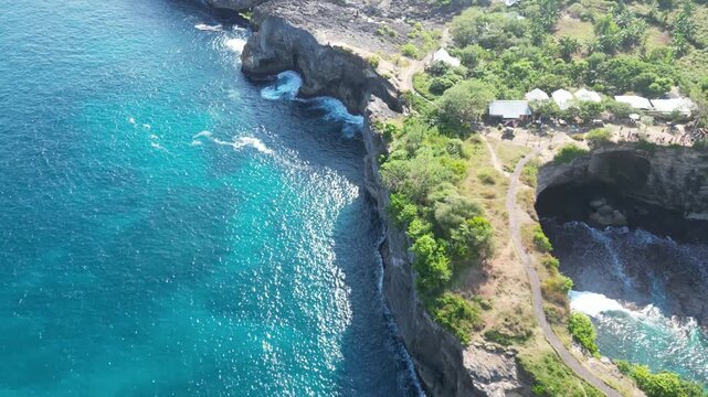 Stunning aerial footage showcasing the natural rock arch Ole Oli at Broken Bay Cliff on Nusa Penida island, Bali. Captured by drone with crystal clear waters and dramatic cliffs.