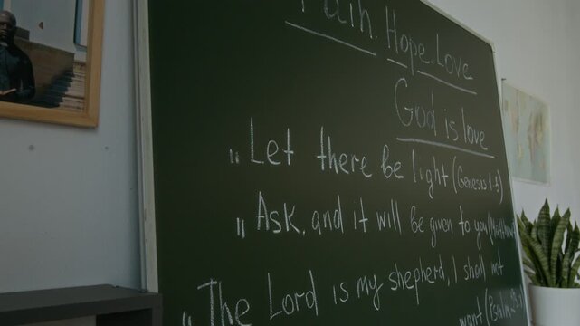 No people shot of school chalkboard with quotes from Bible in modern classroom prepared for religious studies