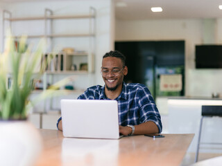 African American Man Calling While Working on Laptop