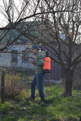 Young man engaged in household chores and small-scale rural farming, tending to his garden with...