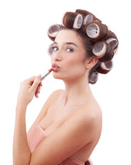 Make up, young woman with hair curlers applying lipstick on kissing lips while looking at the...
