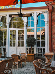 Bright restaurant facade with arched windows and balcony plants