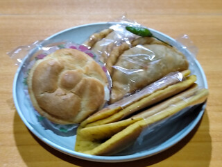 Various typical Indonesian market snacks, on white plates, displaying detailed textures and colors of traditional snacks.