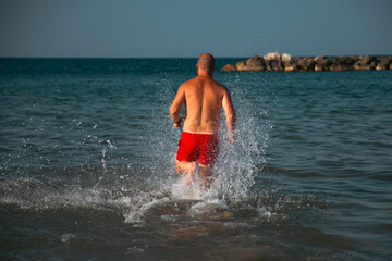 Happy man running on the beach.