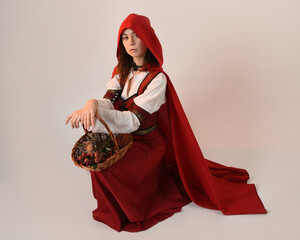portrait pretty young female brunette model wearing a red hooded fairytale cloak and medieval...