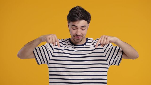 Young Man Points Both Index Fingers Downward To Indicate Area Below 