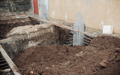 Freshly excavated site showing early foundation work with reinforced concrete footings, exposed...