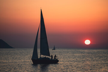 Sailing boat silhoutted against the orange sky