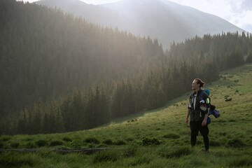 Fototapeta premium Hiker in Khomiak Mountain standing in front of majestic Sunset and Mountain peaks