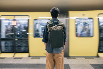 Teenager student girl standing at the subway station waiting for the train to arrive