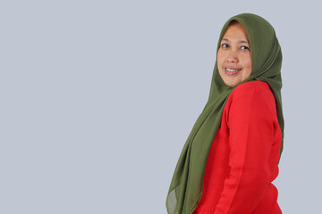 Confident middle aged Muslim woman smiling at camera, isolated studio shot for diversity,...