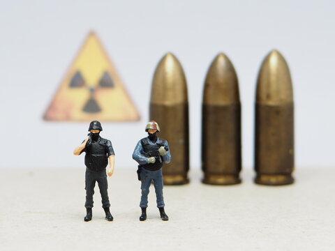 Mini toy of action figure at bullet missile with blurred background. Miniature diorama photography concept design. Minifigure of military crew with balistic rudal weapon.