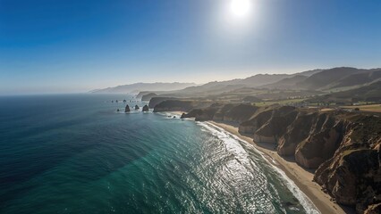 Obraz premium Aerial perspective of coastal scenery with ocean, sky, and lush greenery during summer
