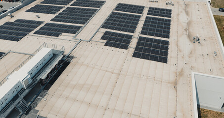 Solar panels and hvac system generating renewable energy on industrial building rooftop © Doralin