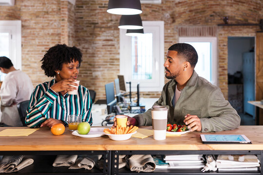 Office workers enjoying break time with healthy snacks and drinks