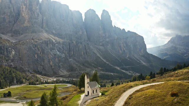 Aerial view of the Pizes de Cir, a majestic mountain range with a quaint church nestled in the foreground, S&euml;lva, Trentino-South Tyrol, Italy.