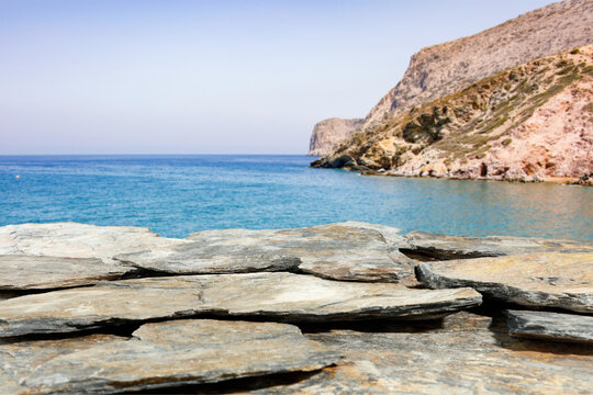 Close up of rocky coast of the sea. Blurred sea, rocky cliff mountain and sky background. Copy space for product placement. - Powered by Adobe