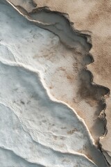Mineral terraces with white and tan hues displaying detailed textures and patterns from a high angle