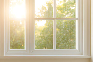 Obraz premium Sunlight streams through a window with a view of trees, creating a serene and bright ambiance. Captured in a home interior, it evokes calmness and freshness.
