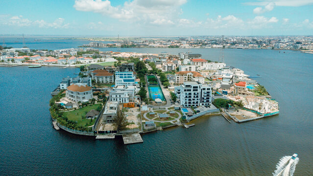 Aerial view of opulent residences nestled on an island surrounded by the vast, shimmering waters of Lagos Lagoon, a testament to luxury living, Lagos, Lagos, Nigeria.