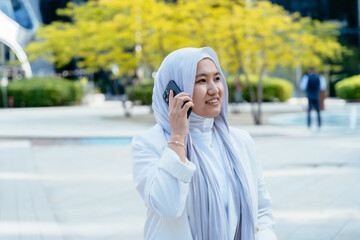 Muslim businesswoman talking on phone in office district