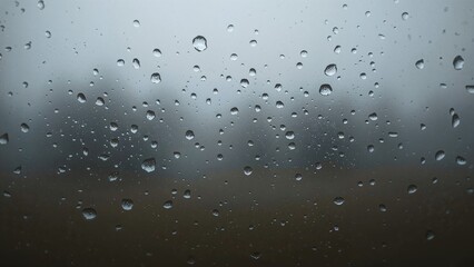 Water beads on glass with blurred backdrop