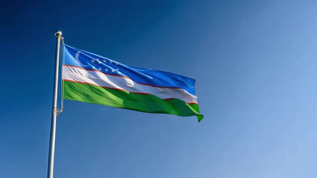 The flag of Uzbekistan flies high under a bright blue sky, displaying its vibrant colors and intricate patterns symbolizing national pride.