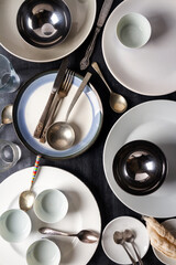 Top view of an empty plates, bowls, glasses and cutlery placed on a black chalkboard background. Flat lay. Top view. Food concept.