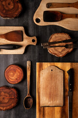 Naklejka premium Wood log tree slices and cutting boards on black chalkboard. Flat lay. Top view