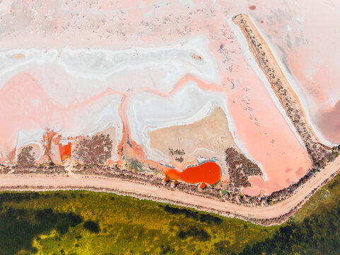 Aerial view of colourful salt evaporation pond and levee banks at a coastal salt farm