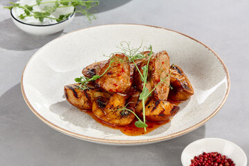 Pork medallions with sweet chili sauce, grilled potatoes, mushrooms on bright overhead minimalist plate