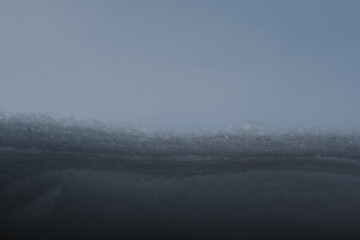 Fototapeta premium Snow layered behind window glass on a frosty morning