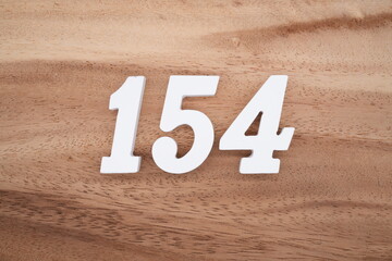 The numbers are made of white painted wood placed on a brown wooden floor.