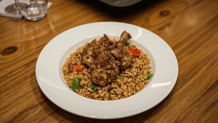 Traditional bulgur rice mixed with seasoned meat and vegetables arranged on a white plate for food service listings