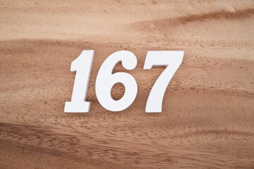 The numbers are made of white painted wood placed on a brown wooden floor.