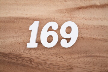 The numbers are made of white painted wood placed on a brown wooden floor.