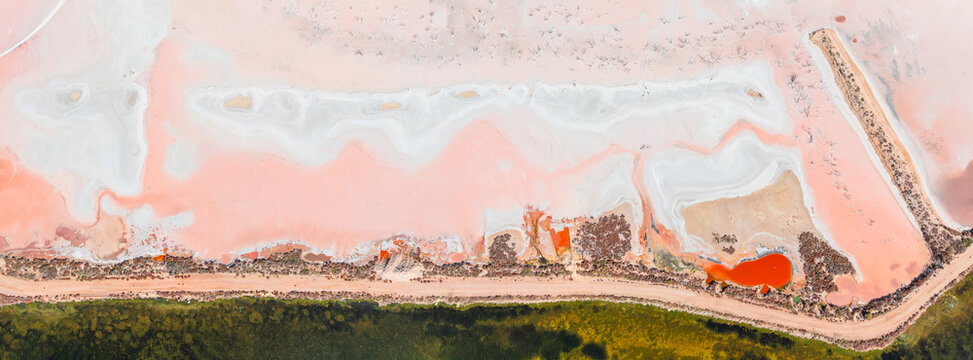 Aerial panorama of coloured evaporation ponds at a coastal salt farm