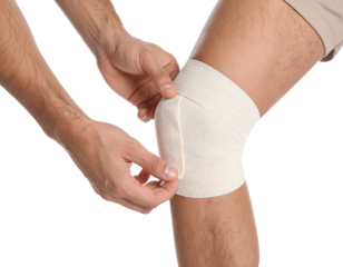 Hands securing a bandage around a person’s knee