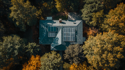 Aerial View of Residential House with Solar Panels Surrounded by Trees