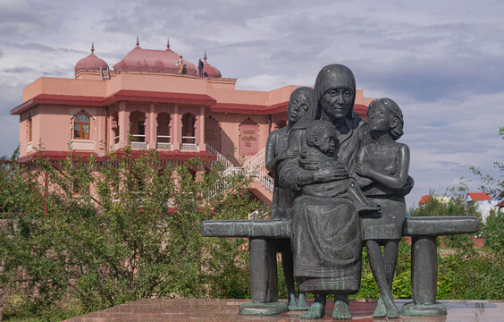 Kaluga, Russia; August 8 2024: Statue of Mother Teresa of Calcutta with three children, sitting on a bench, in the Etnomir ethnographic park, in the Kaluga region, Russia