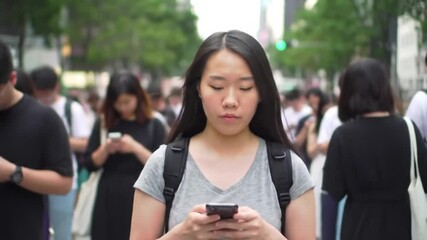 Urban scene of a young woman focused on her phone, amidst a crowd walking in a city - Powered by Adobe