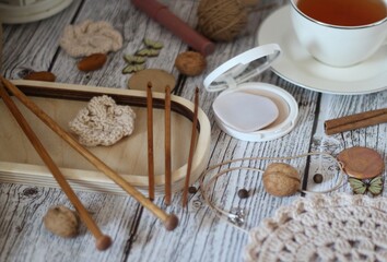 Woman's different things cup of tea, make up, ball clew yarn, mirror doily cozy photo beige pastel...
