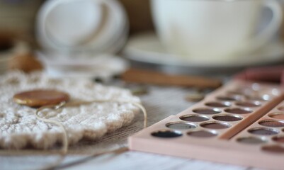 Woman's different things cup of tea, make up, ball clew yarn, mirror doily cozy photo beige pastel light colors	
