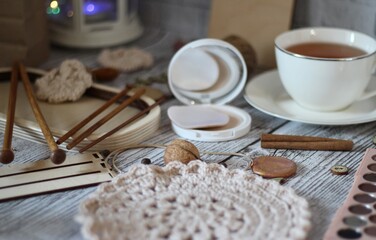 Woman's different things cup of tea, make up, ball clew yarn, mirror doily cozy photo beige pastel...