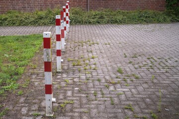 Red and white traffic bollards defining parking space limits
