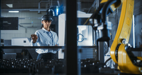 Obraz premium Multiethnic Female Engineer in a Mixed Reality Headset Skillfully Controls a Robotic Arm in a High Tech Manufacturing Facility, Demonstrating Advanced Functionality and Precision Engineering