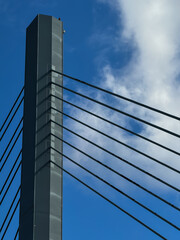 Fototapeta premium Modern Cable-Stayed Bridge Against Blue Sky with Clouds and Urban Surroundings